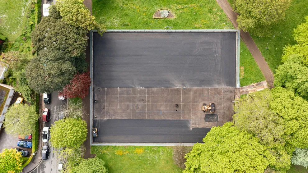 top down perspective of a tennis court being resurfaced