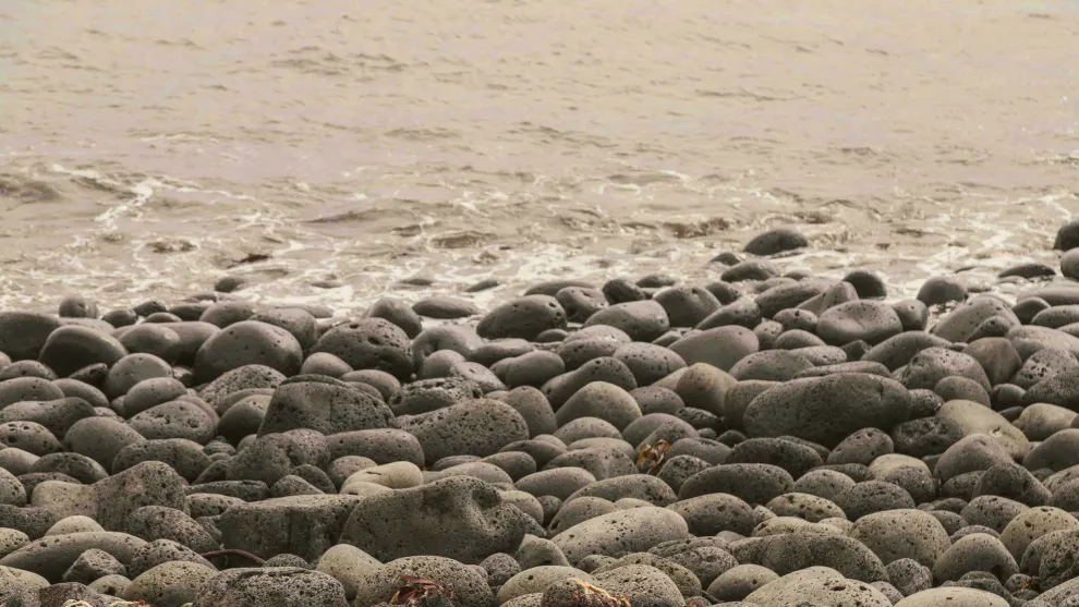 Pebbles on a beach leading into the sea