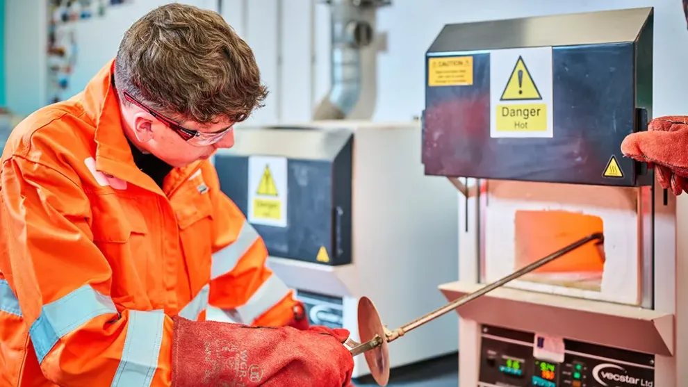 PPE dressed worker in a lab performing a test