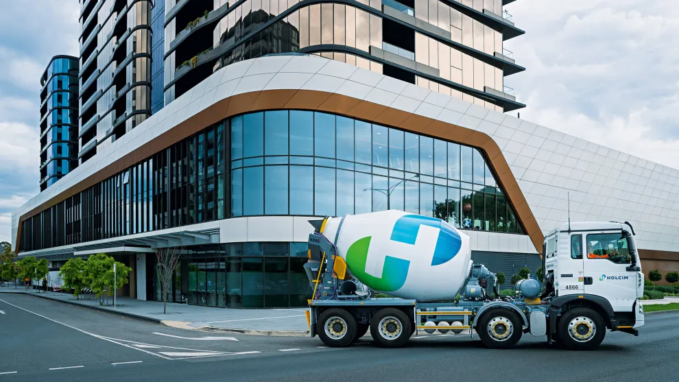 Holcim cement mixer in front of the corner of a building