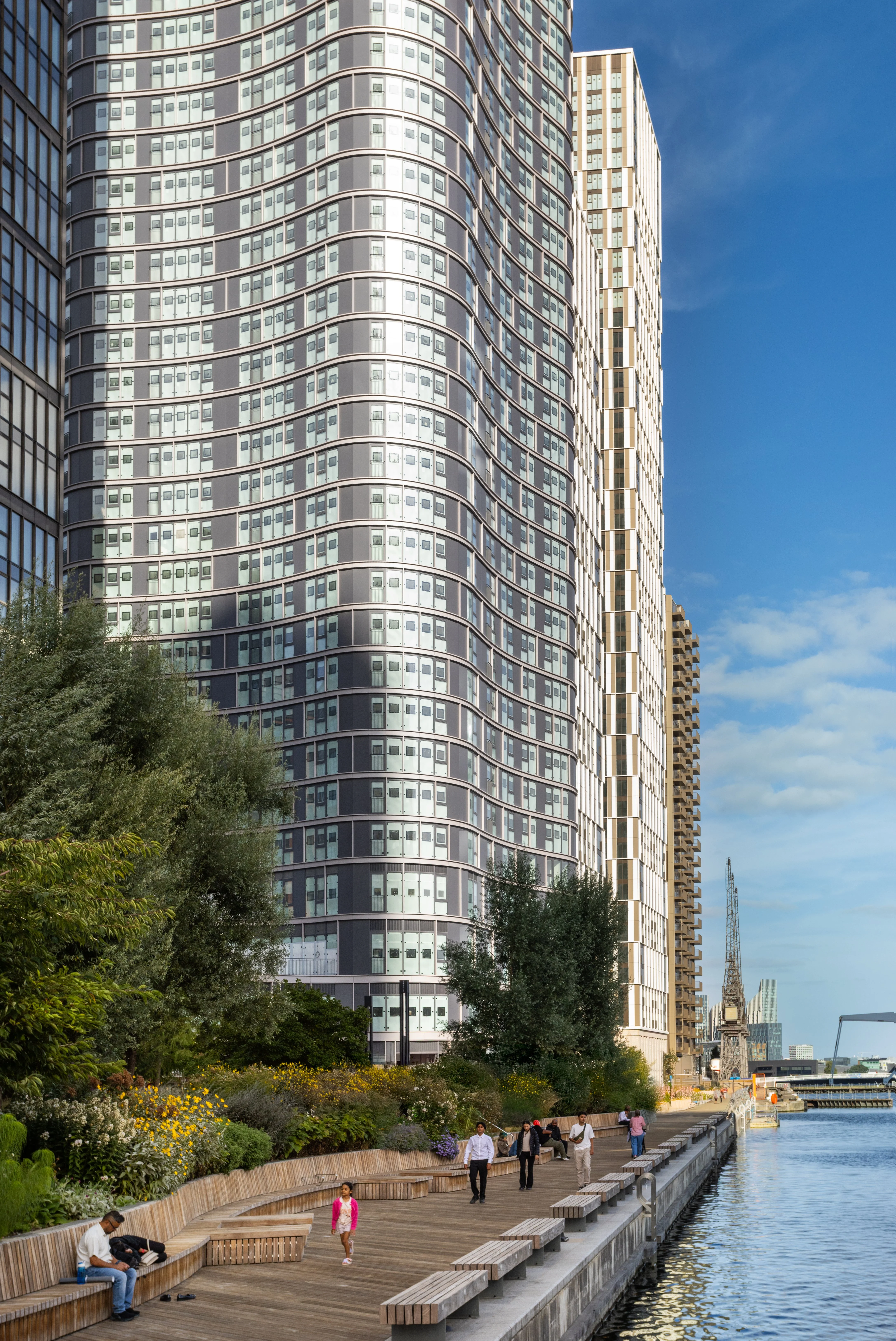 Tall building next to trees and a path on the river thames