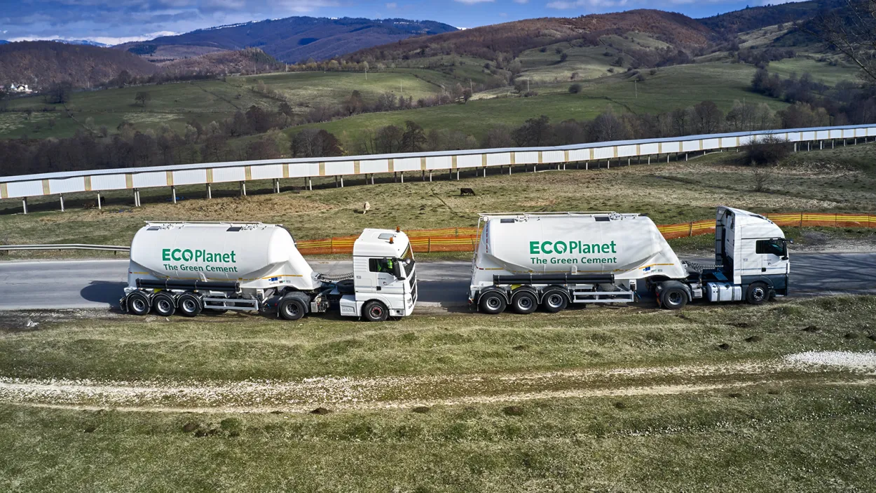 Two cement tankers with the Ecoplanet green cement logo on the side driving through the countryside