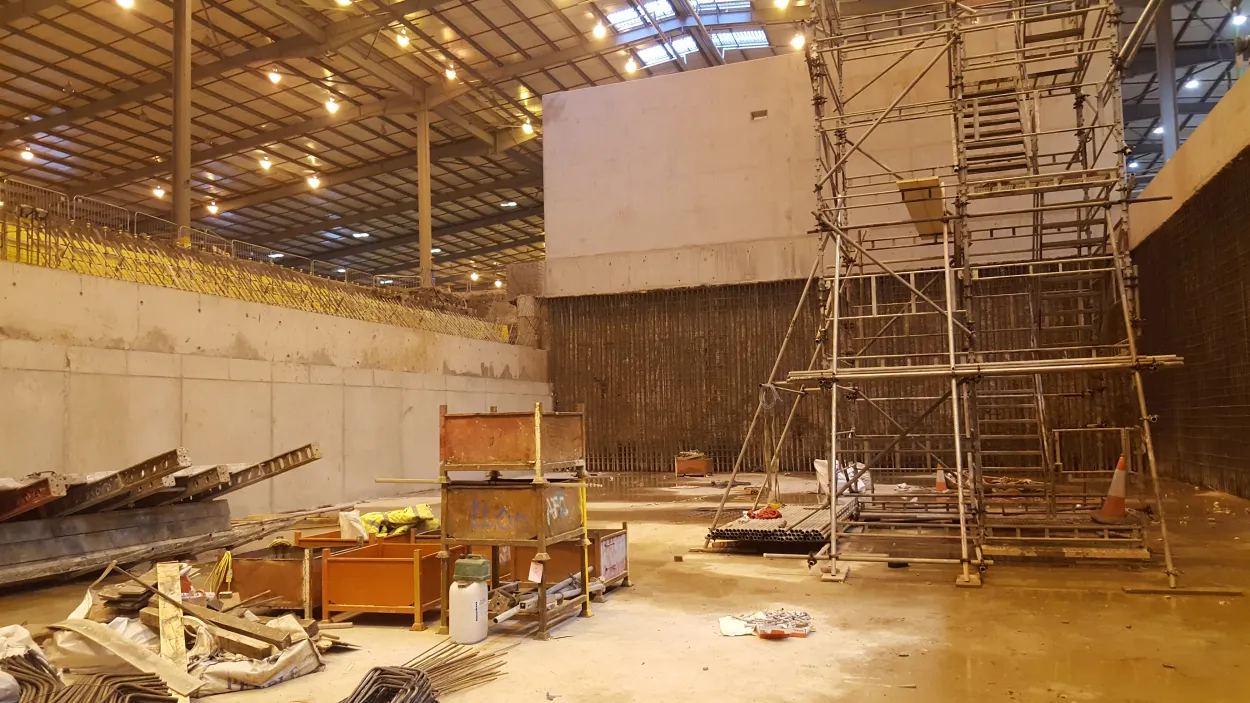 Inside a large building with demolished material and concrete