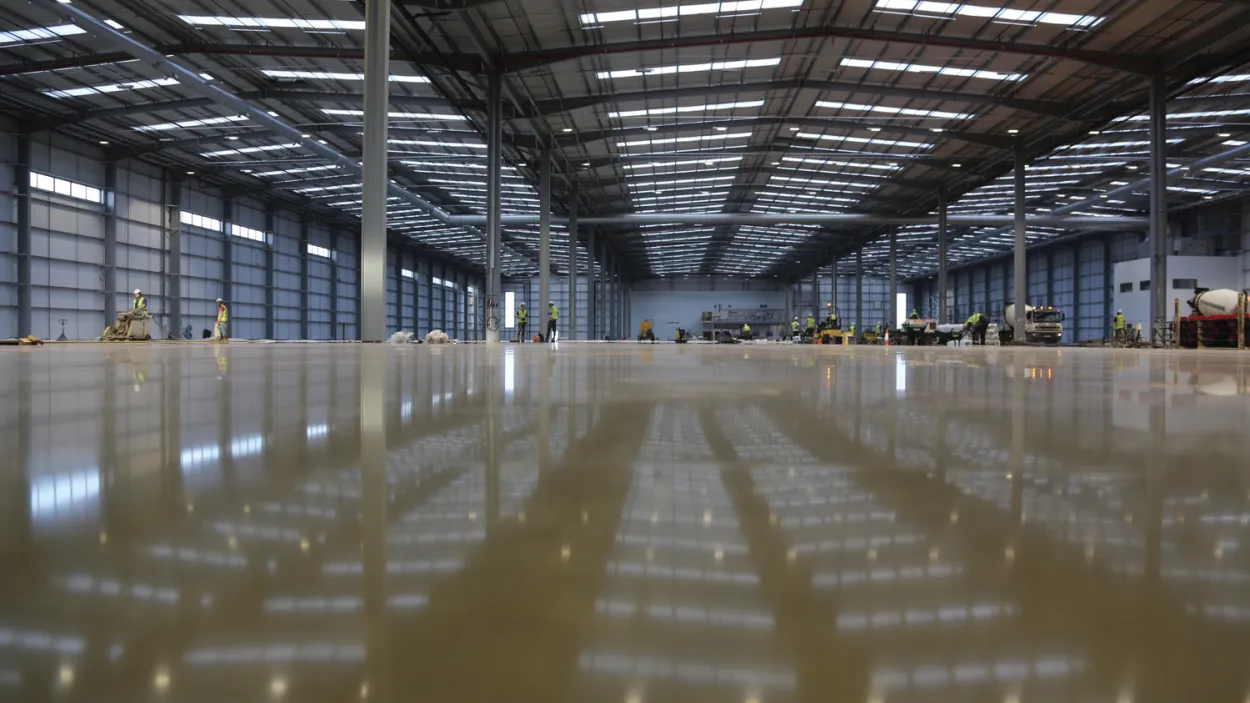 Newly constructed empty warehouse with wet screed on the floor