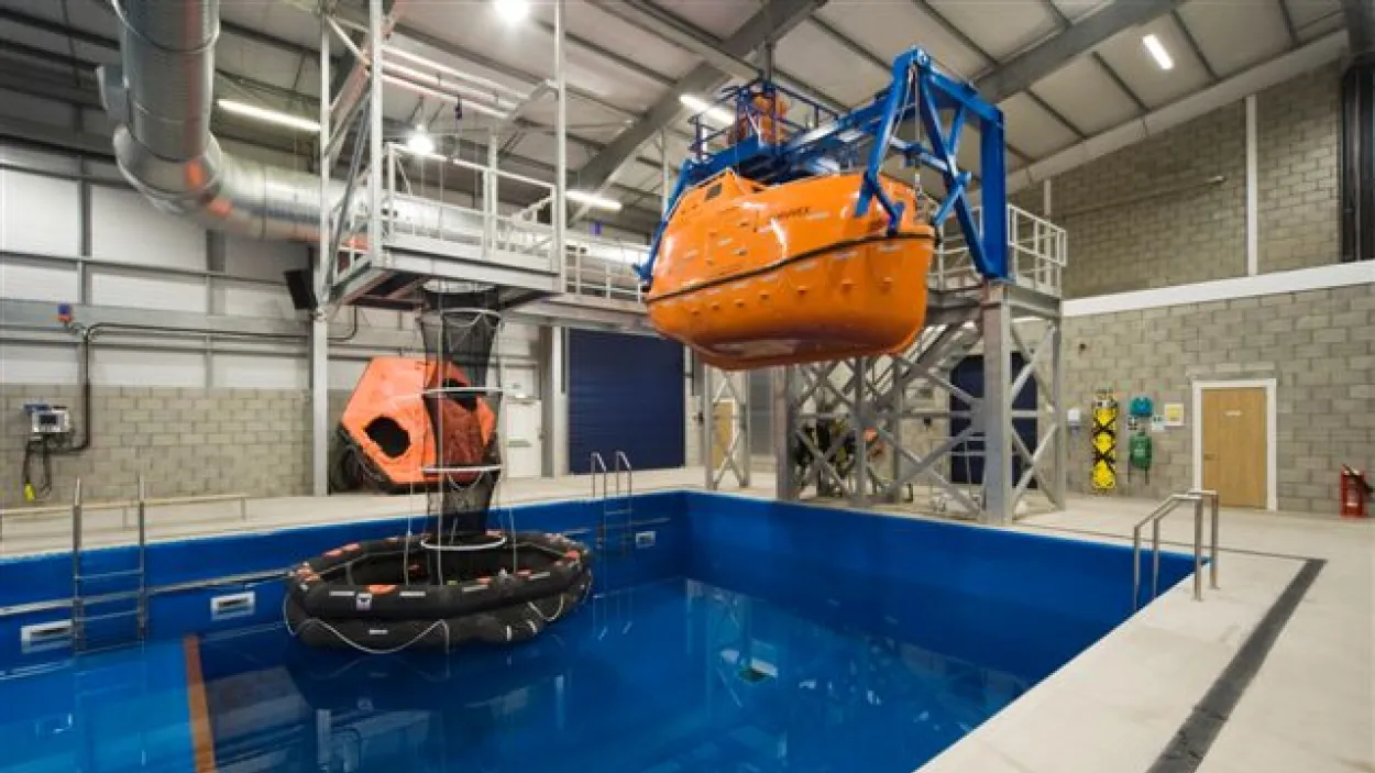 Pool with a boat hung above it inside a large building