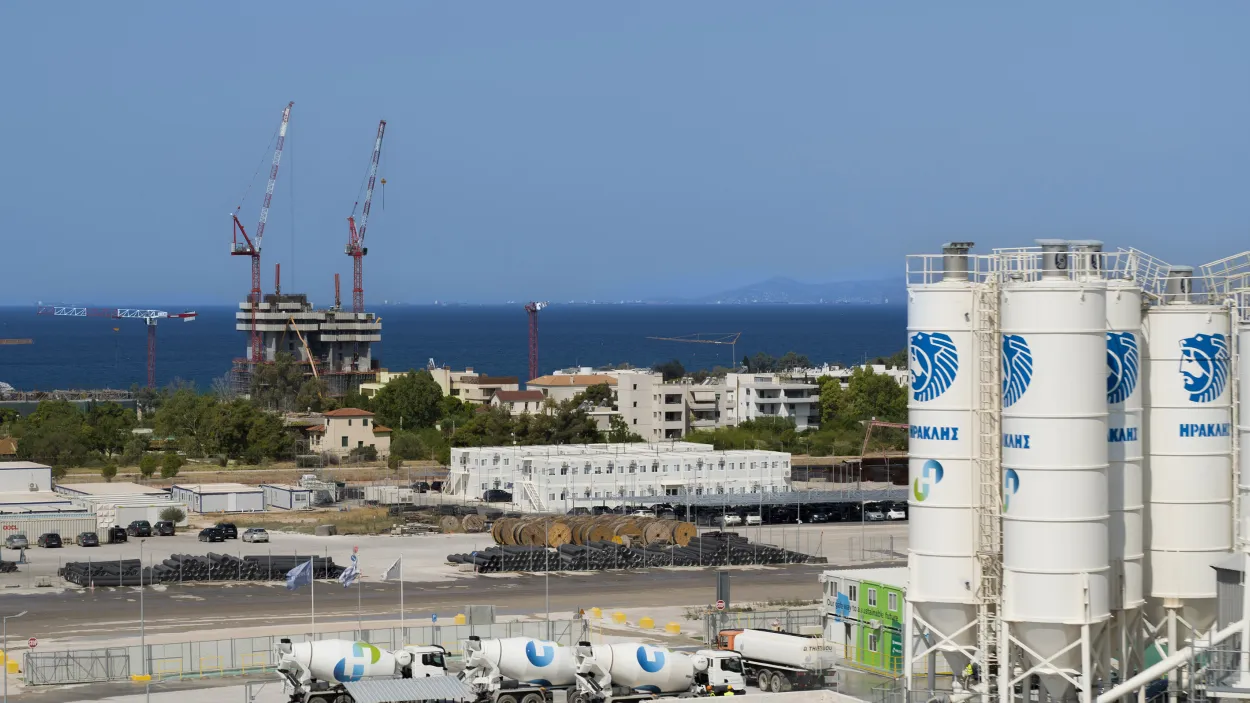 Ellinikon cement plant with mixer trucks and a tower under construction in the background