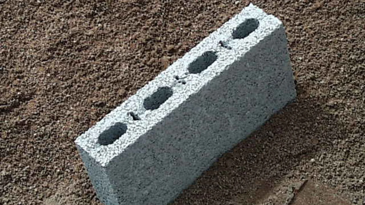 Lightweight concrete aggregate building block resting on a bed of fine sand.