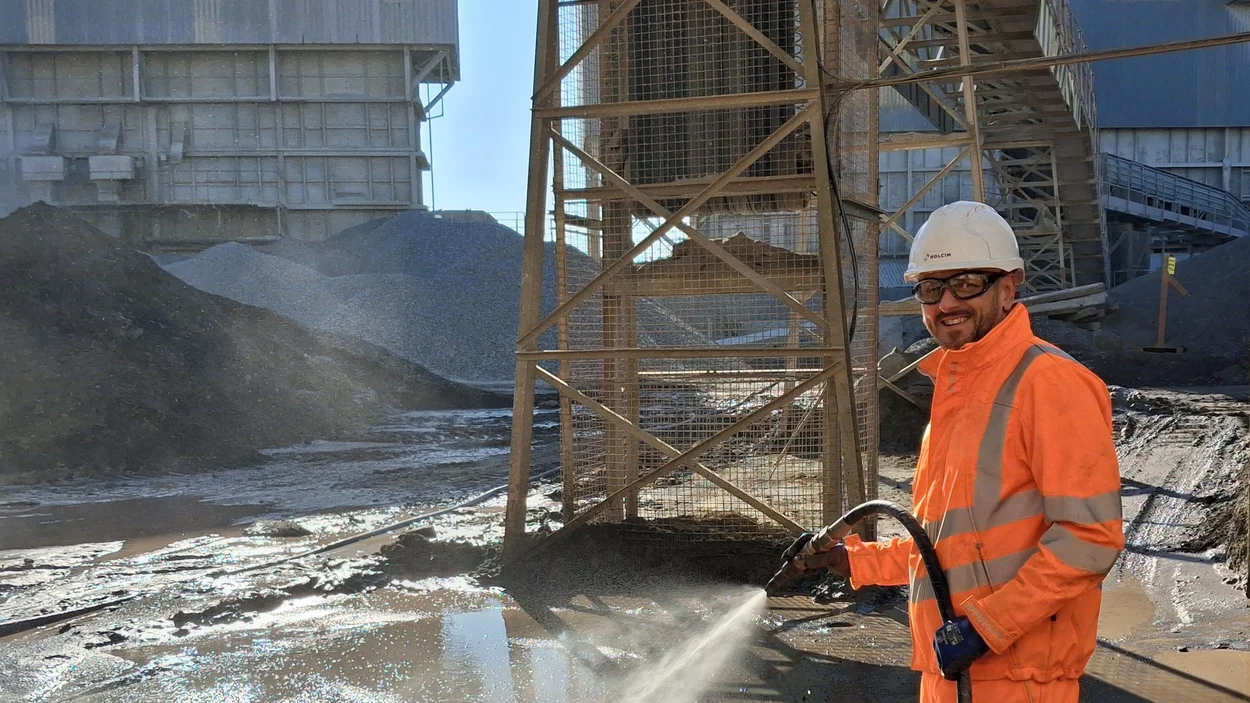 Managing Director of Aspahlt, Danny King, in high viz PPE jetwashing at Bardon Hill asphalt plant
