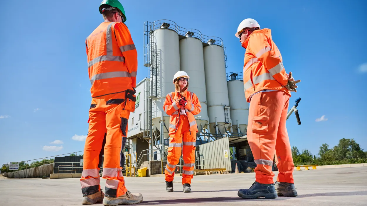 Laura Golledge, East Midlands RMX General Manager, in her PPE at the Whestone RMX Plant in Leicester in conversation with two colleagues