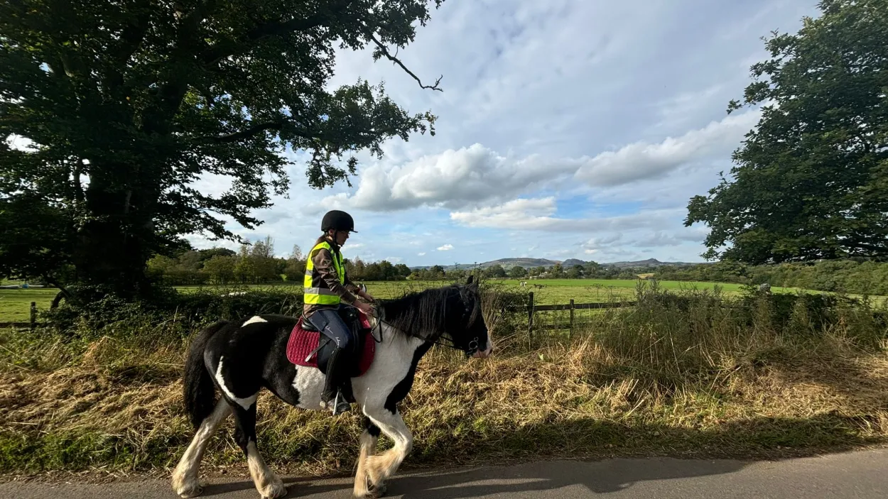 Holcim apprentice Morgan Watson riding a horse along a country lane.