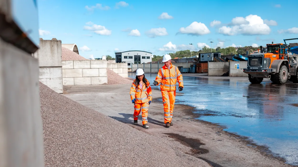Rob Walsh in high viz PPE walking through the Land Recovery site in Stoke with colleague Sonia Martinez.