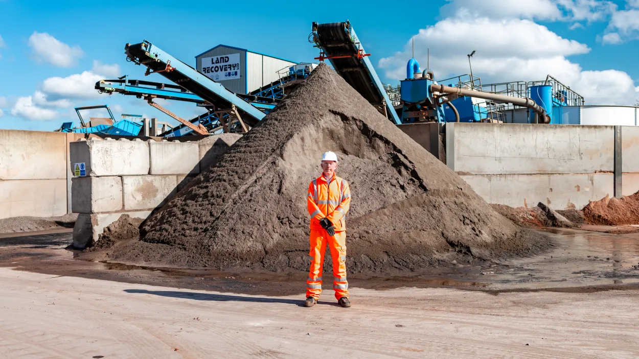 Rob Walsh in high viz PPE in front of recycled aggregate at Land Recovery Stoke