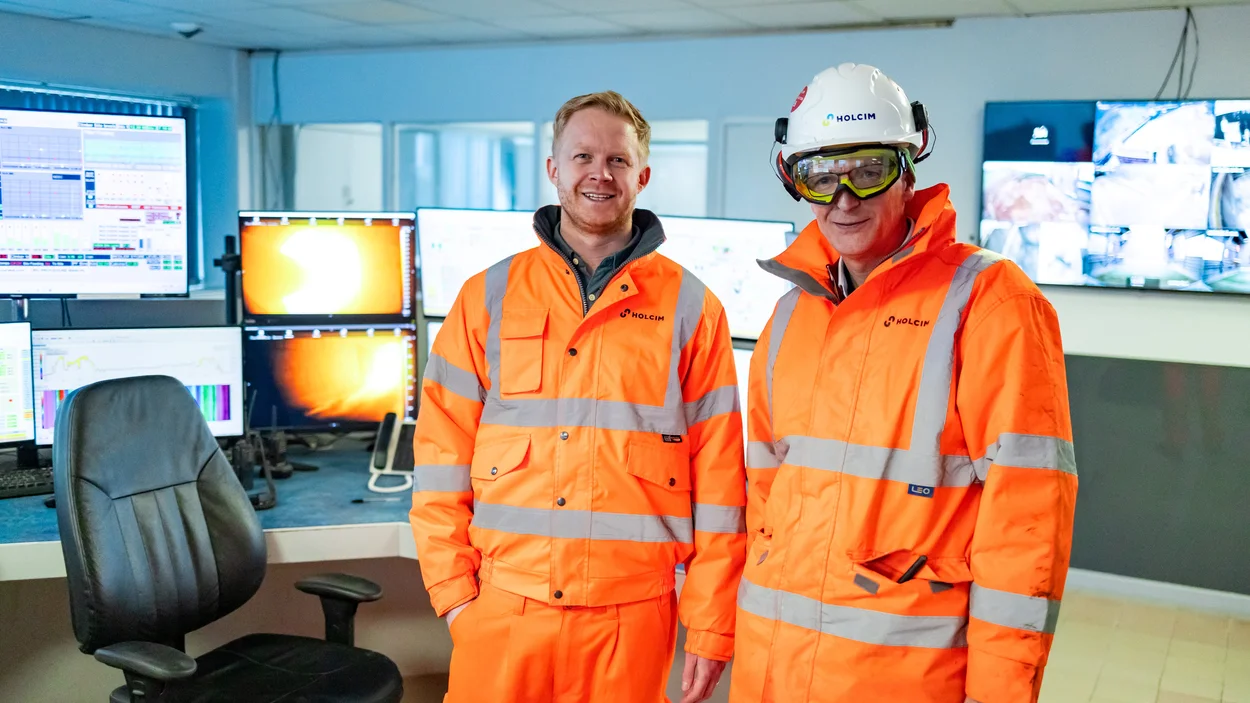 Holcim UK Head of Sustainability Tom Redfern in high viz PPE in the Cauldon Cement control room with a colleague
