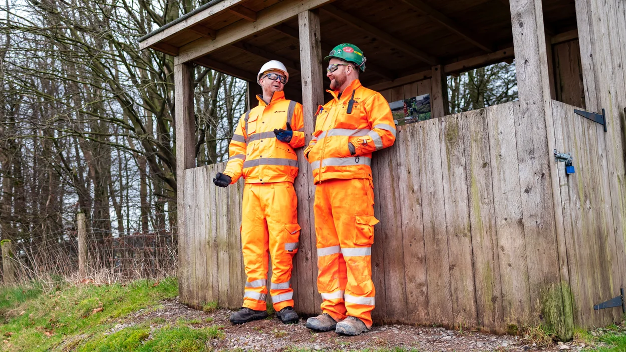 Holcim UK Head of Sustainability Tom Redfern in high viz PPE with a quarry in front on a nature hide at Cauldon Quarry in Staffordshire