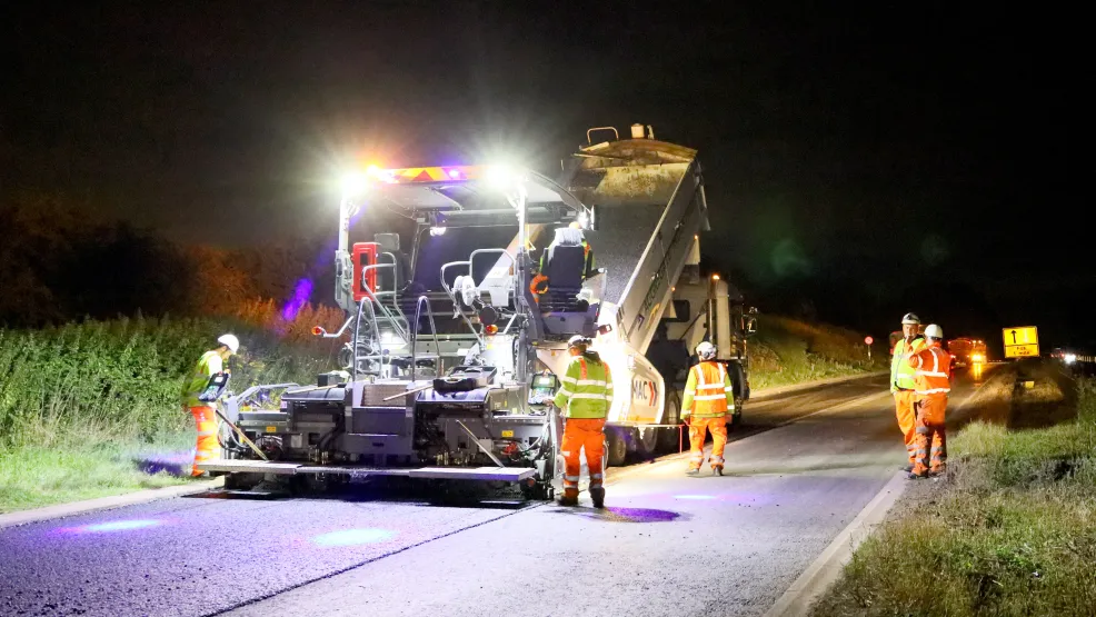 Workers laying asphalt on the A46 at night