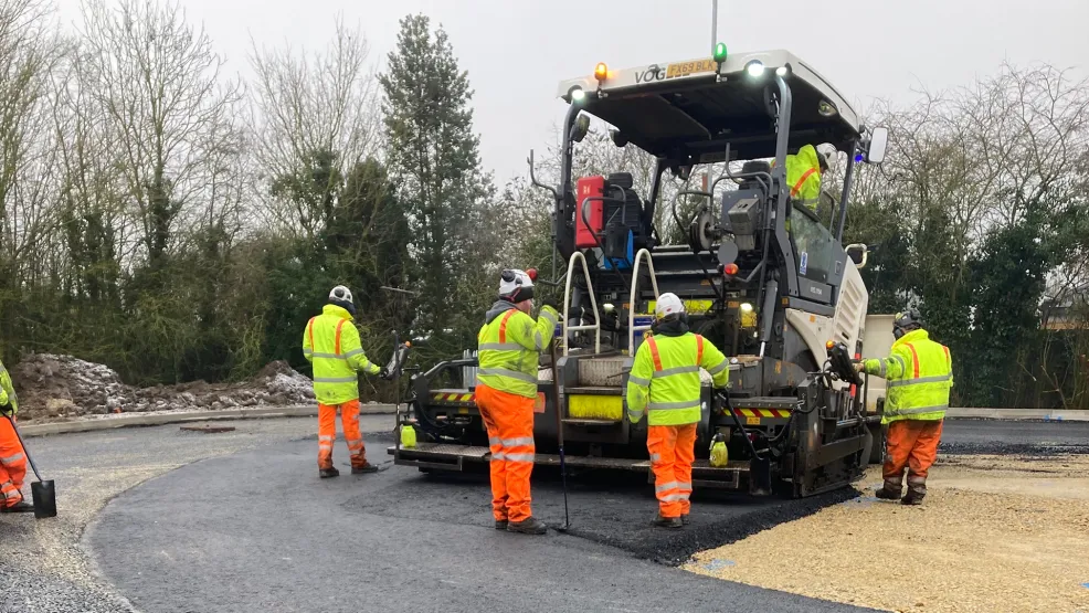 Workers walking with paver in action
