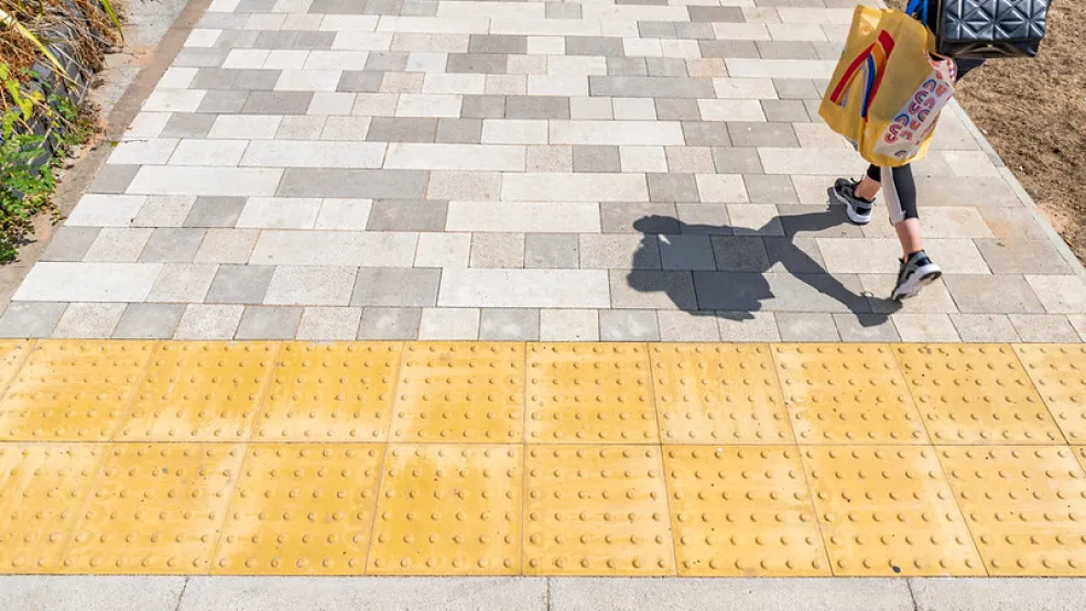 Orange demarcation kerbs next to grey block paving