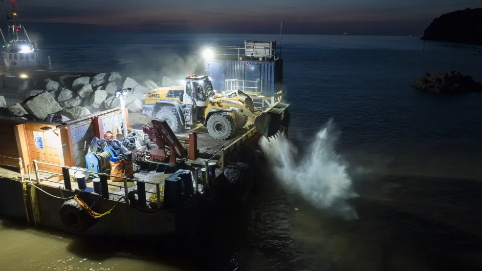 Rockarmour boulders being dropped onto the Blue Anchor coastline at night