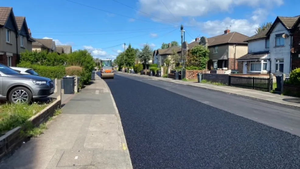 Roller further down the road flattening fresh asphalt