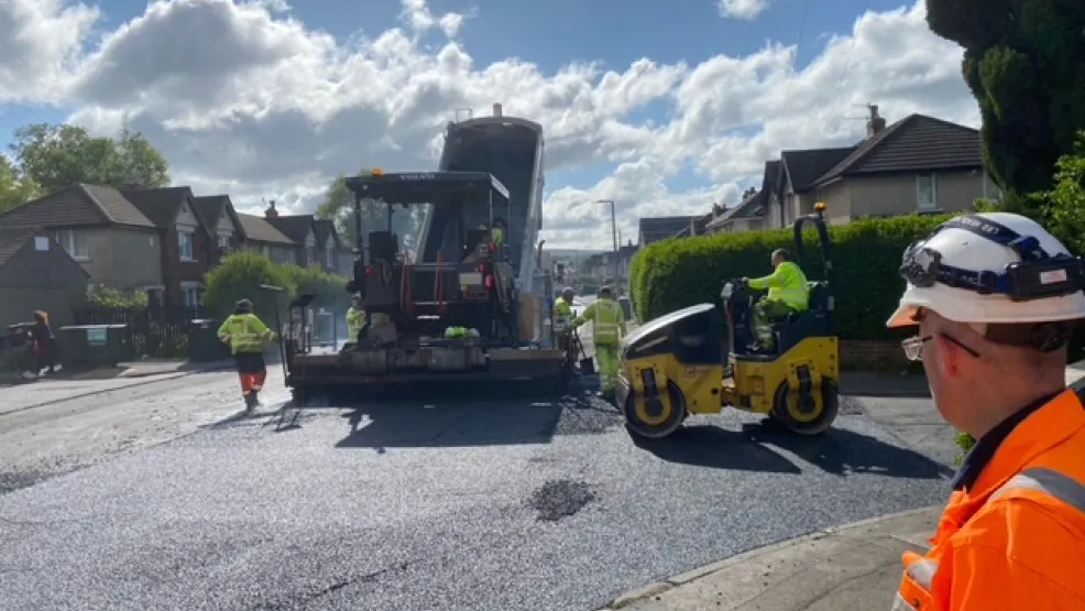 Asphalt being tipped into a paver