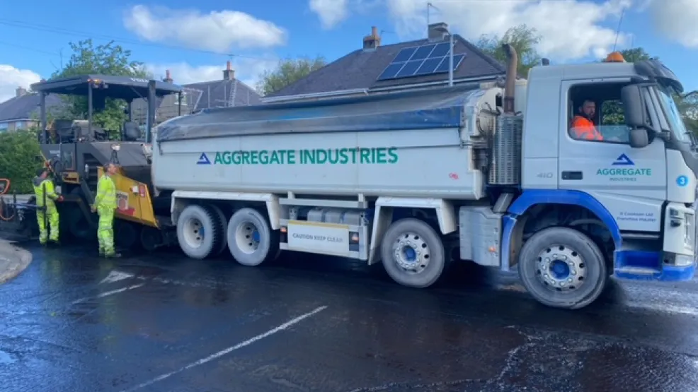 Tipper truck in front of a paver about to tip asphalt into it