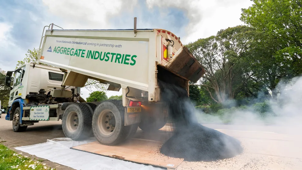 Aggregate Industries tipper truck dumping steaming asphalt onto the ground
