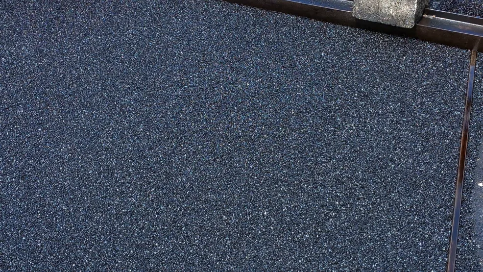 Fresh asphalt being laid alongside tramlines