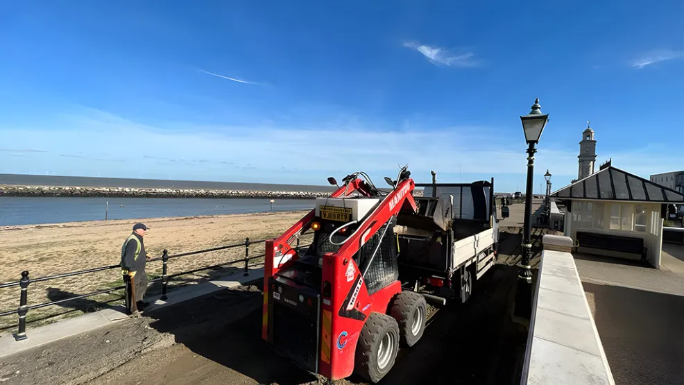 Mini Tipper collecting asphalt from the back of a flatbed truck
