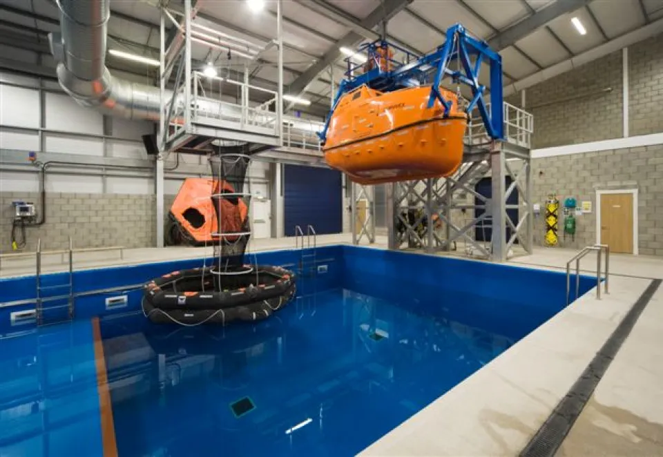 Pool with a boat hung above it inside a large building