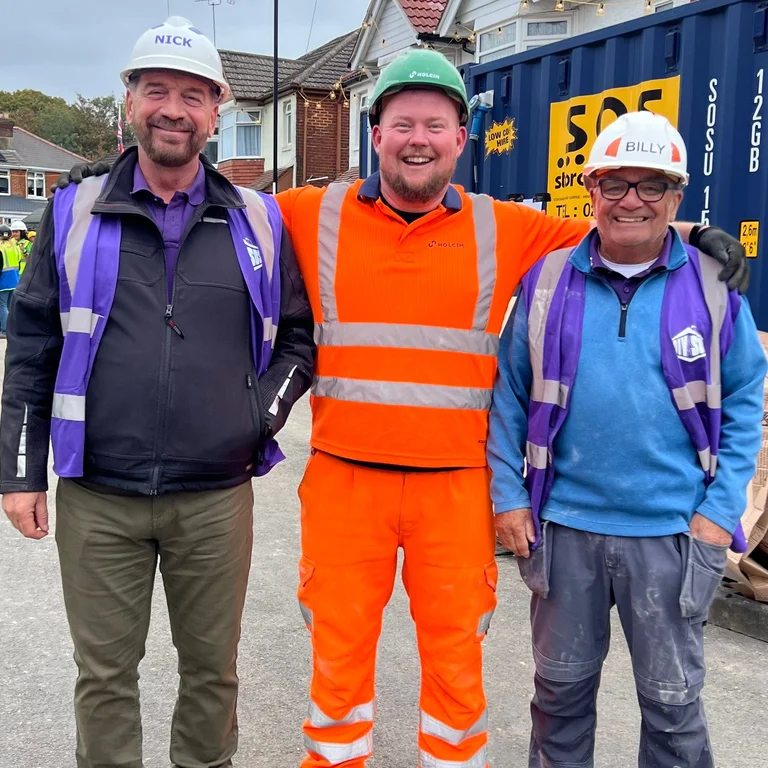 Chris Davison in orange PPE on the set of DIY SOS in Southampton with Nick Knowles and Billy Byrne from the show