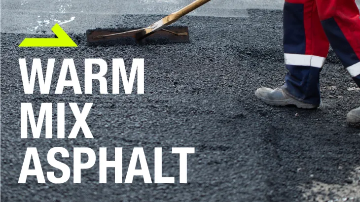 Worker smoothing warm mix asphalt