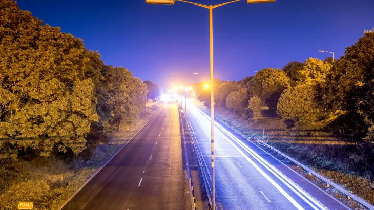 SuperThin asphalt on a road at night with light streaks from cars