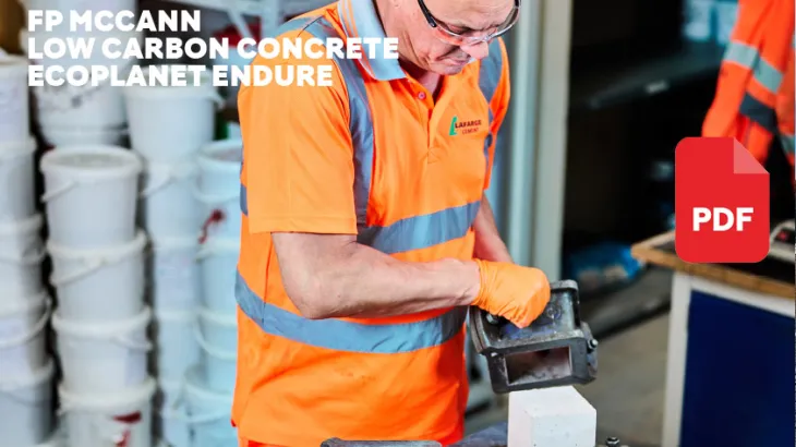 Worker in PPE removing concrete block from mould
