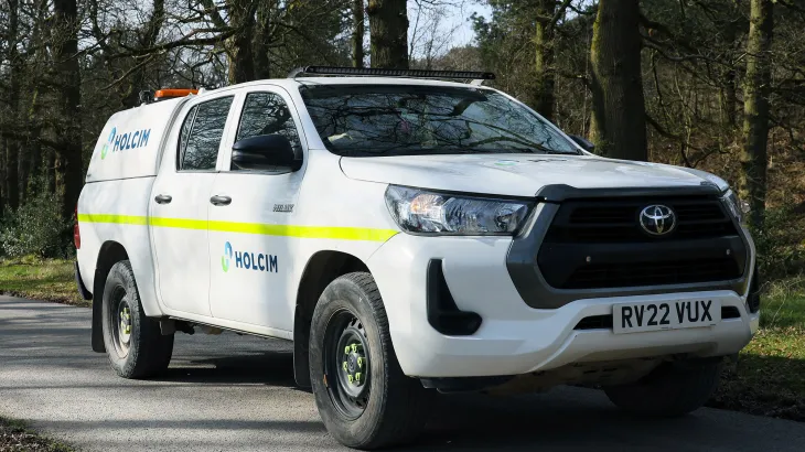 Toyota pickup truck with Holcim branding on a road