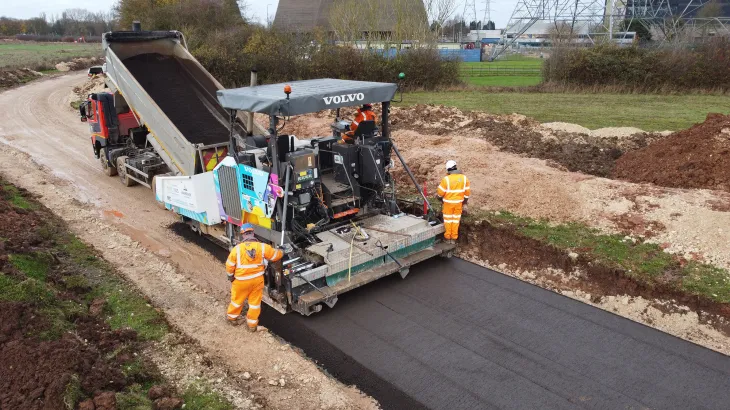 Workers paving a new road through a rural area