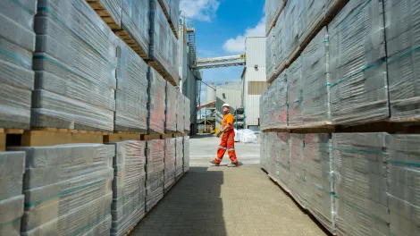 Man walking past concrete block stockpile in yard