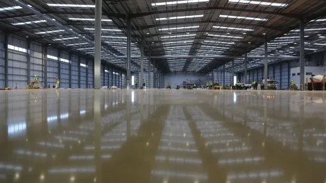 Newly constructed empty warehouse with wet screed on the floor