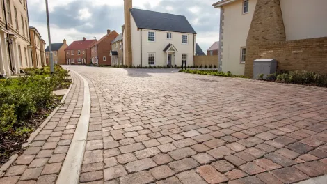 Paved road with modern bricked houses either side