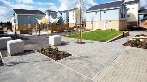 Modern paved area with buildings, grass and bollards