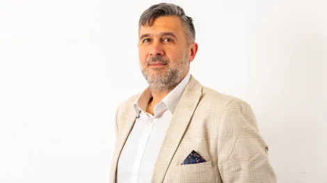Man wearing a white suit posing for a professional photo