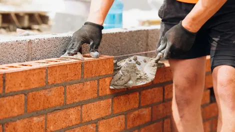 Man laying bricks on a wall