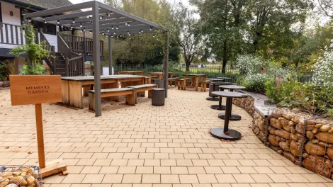 Modern paved garden area with benches, seating, trees and flowers