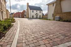 Paved road with modern bricked houses either side