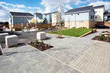 Modern paved area with buildings, grass and bollards