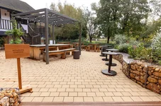 Modern paved garden area with benches, seating, trees and flowers