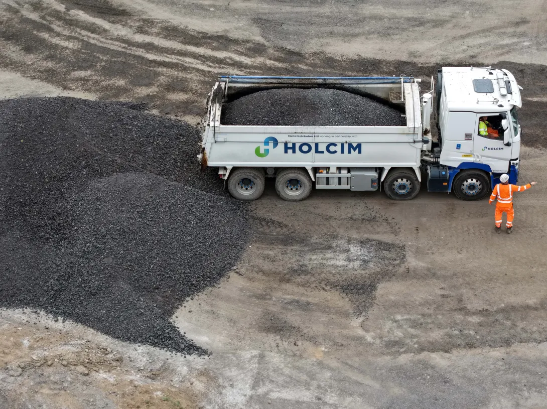 A Holcim truck offloading road planings