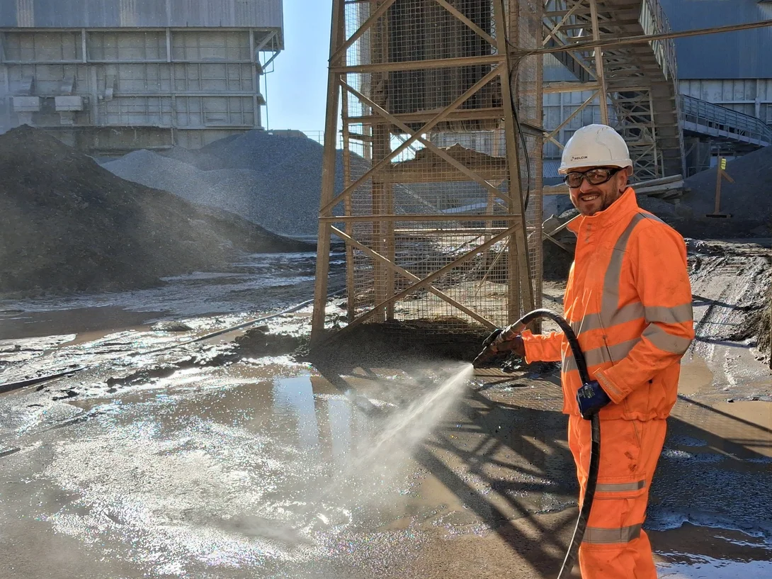 Managing Director of Aspahlt, Danny King, in high viz PPE jetwashing at Bardon Hill asphalt plant