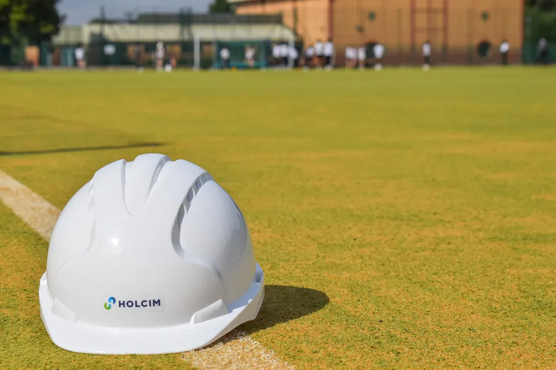 A Holcim hard hat sits on the newly refurbish artificial pitch at St Benedict School in Derby. Holcim UK donated specialist sports sand to the project.