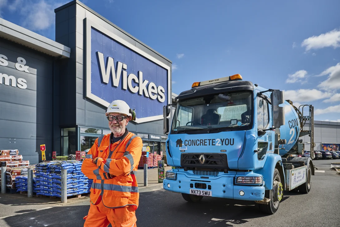 Holcim driver Nick Salsbury in front of the Concrete2You blue mixer truck at Wickes in Wigston.
