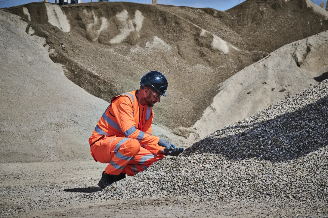 A colleague in high viz takes a closer look at the construction demolition materials processed at Holcim's Morden Wharf Recycling Centre in London.
